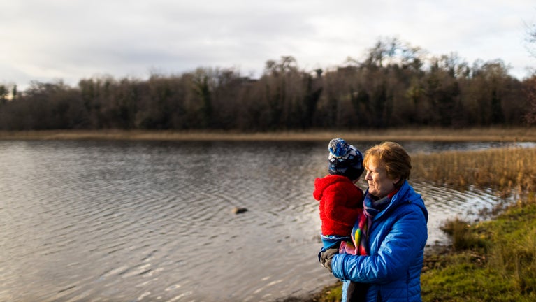 A grandmother holding her grandson looking over Lake Coole at Castle Coole
